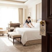 Addetto al controllo dei parassiti con spruzzatore manuale per l’applicazione di pesticidi in uno stabilimento di produzione o manifatturiero